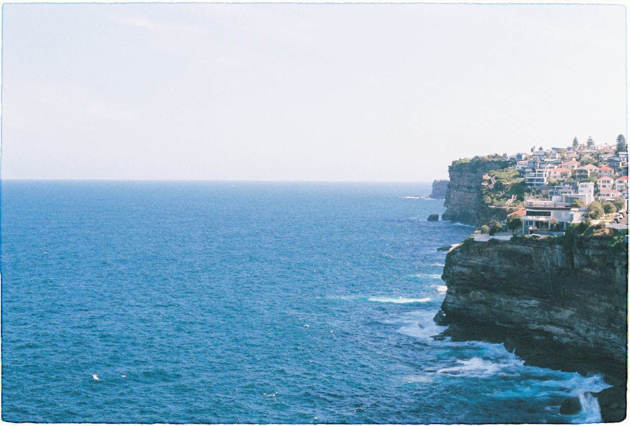 BUILDINGS BY SEA AGAINST CLEAR SKY