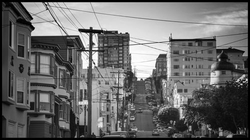 Cars on road against sky in city