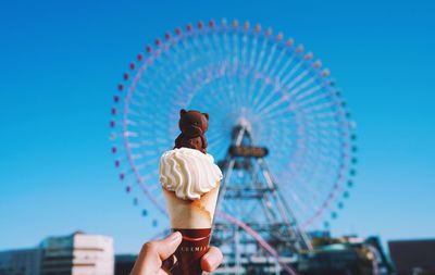 Close-up of ferris wheel against blue sky