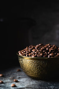 Close-up of coffee beans on table against black background