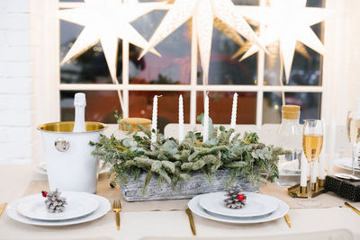 Beautiful table setting with christmas tree decorations in the living room against 