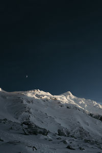 Scenic view of snowcapped mountains against sky at night