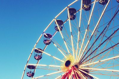 Low angle view of illuminated ferris wheel against clear sky