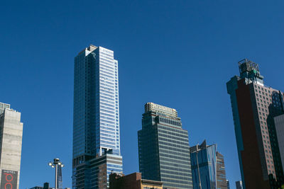 Low angle view of modern buildings against clear blue sky