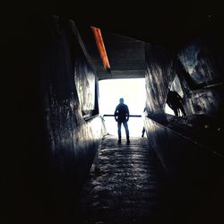 Rear view of man standing in tunnel