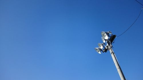 Low angle view of street light against blue sky