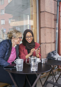 Female friends having coffee in outdoor cafe