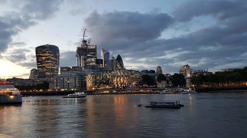 City at waterfront against cloudy sky