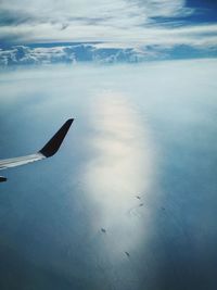 Airplane flying over sea against sky