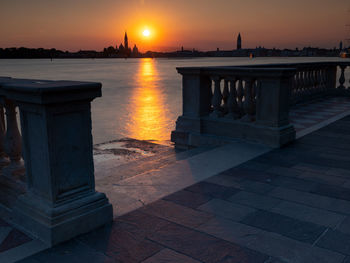 View of building at waterfront during sunset