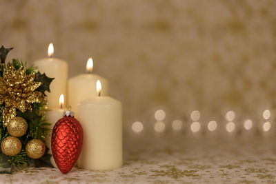 Close-up of christmas decorations with candles on table