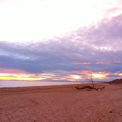 Scenic view of beach against cloudy sky