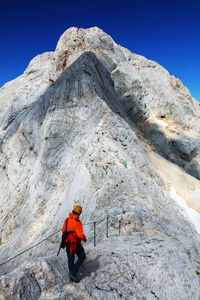 Low angle view of man on rock against sky