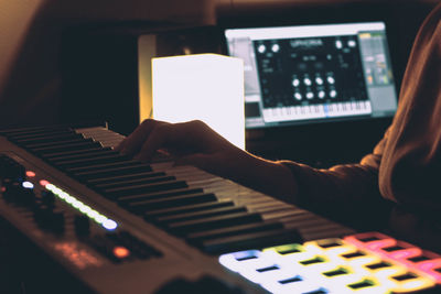 Close-up of person hand playing piano