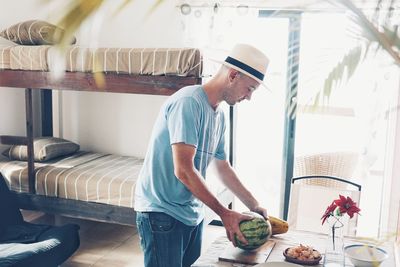 Young man holding fruits at home