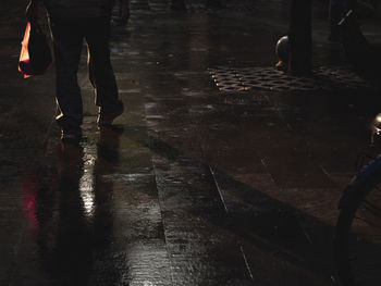 Low section of people walking on wet street during rainy season