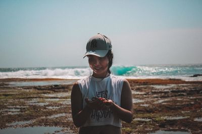 Young man wearing sunglasses standing on beach