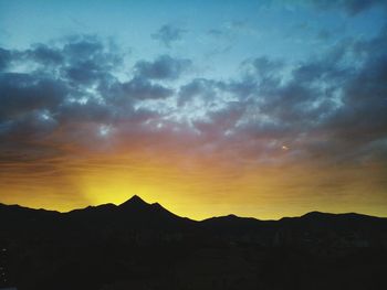 Scenic view of silhouette mountains against sky during sunset