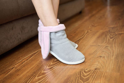 Low section of woman sitting on hardwood floor