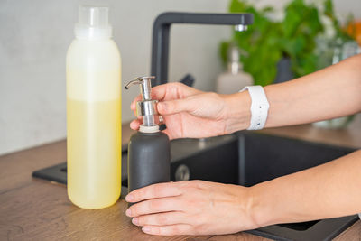 Cropped hands of woman holding bottle