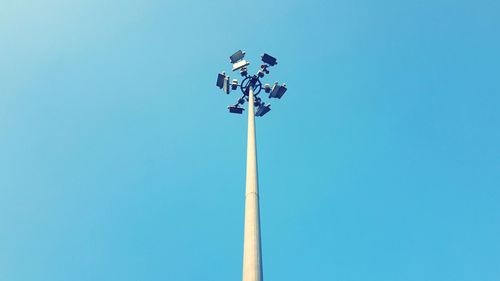 Low angle view of floodlight against blue sky