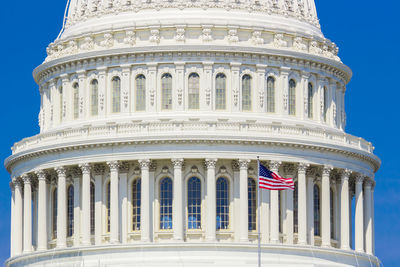 American flag against built structure and blue sky