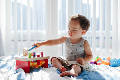 Cute boy playing with toy at home