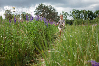 Rear view of woman walking on grassy field