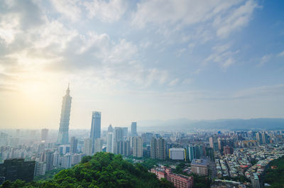 Buildings in city against cloudy sky