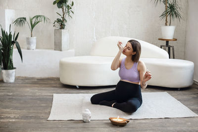 Pregnant woman smelling aroma oil at home