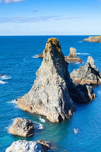 Rock formation in sea against sky