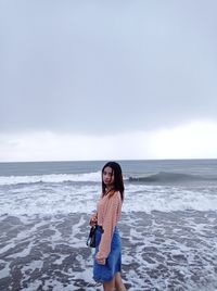 Full length of man standing on beach against sky