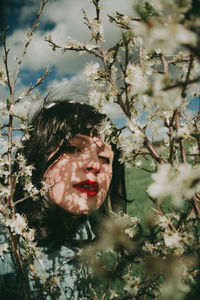 Portrait of woman with pink flowers on tree