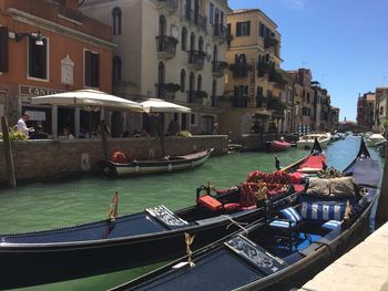 Gondolas in canal against buildings