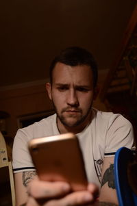 Low angle view of young man using mobile phone at home