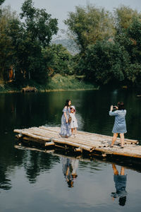 Men on lake against trees