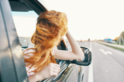 Rear view of woman on road against sky