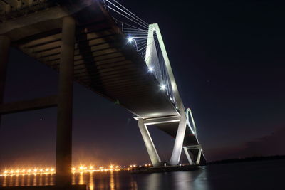 Low angle view of illuminated bridge against sky at night