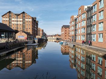 Canal and inland dock amidst buildings in city