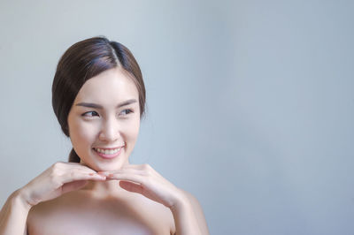 Smiling young woman against gray background