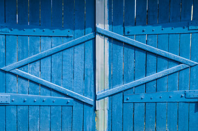 Closed blue wooden vintage gate in the countryside.