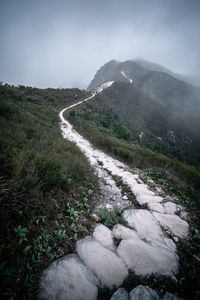 Footpath on landscape against sky