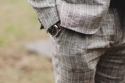 Midsection of man wearing suit while standing outdoors