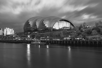 Arch bridge over river against buildings in city
