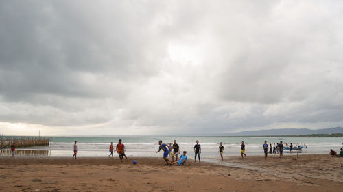 People at beach against sky