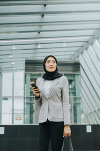 Full length of young woman using mobile phone