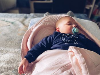 High angle view of baby sleeping on bed