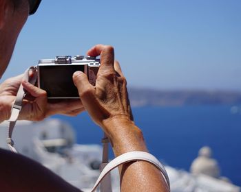 Man photographing sea against sky