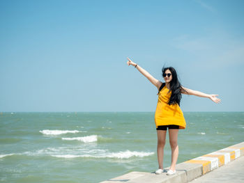 Full length of young woman standing on beach