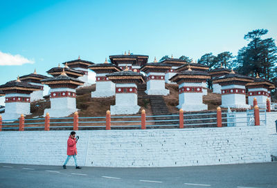 Man walking on road against temple